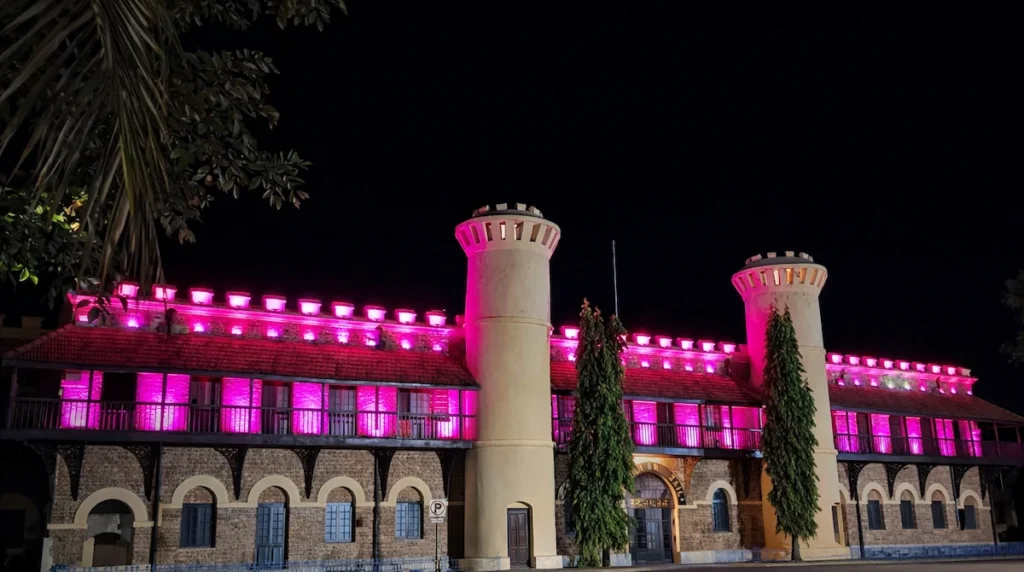 Cellular Jail National Memorial in Port Blair illuminated with pink lights at night, showcasing its historic stone architecture, towers, and colonial-era design against a dark sky in Andaman and Nicobar Islands.