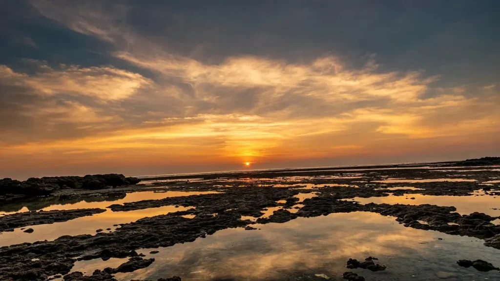 Neil Island: The Perfect Escape from Crowded Island Life Golden sunset at Laxmanpur Beach, Neil Island (Shaheed Dweep), Andaman and Nicobar Islands with dramatic orange sky reflecting in natural rocky tidal pools