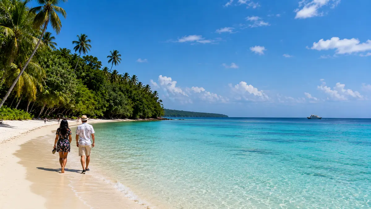 Tropical scenery of Andaman beaches featuring coconut palm trees and clear blue ocean waters.