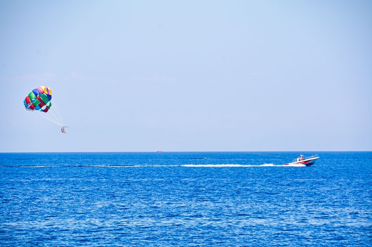 Experience the thrill of parasailing above azure Mediterranean waters near Rhodos, Greece.
